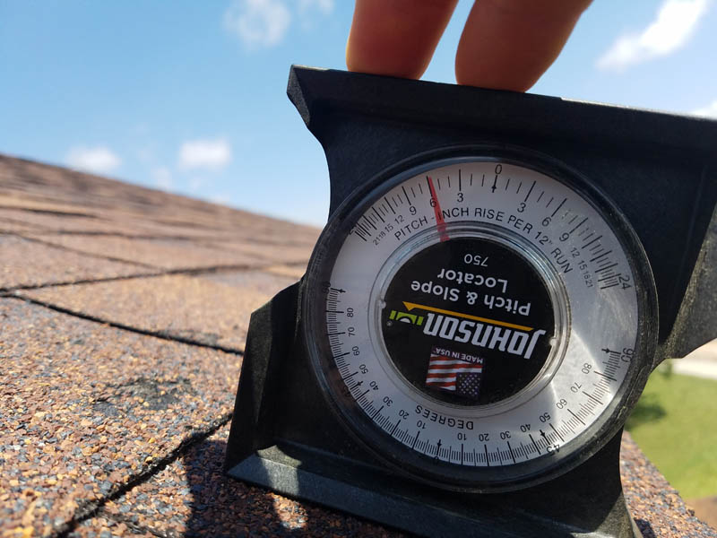 roof pitch gauge on roof inspection